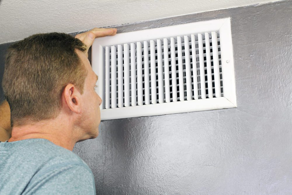 man closing air vent in house